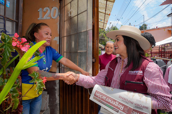 Gladyz Butanda distribuye periódico Regeneración en colonias de Pátzcuaro